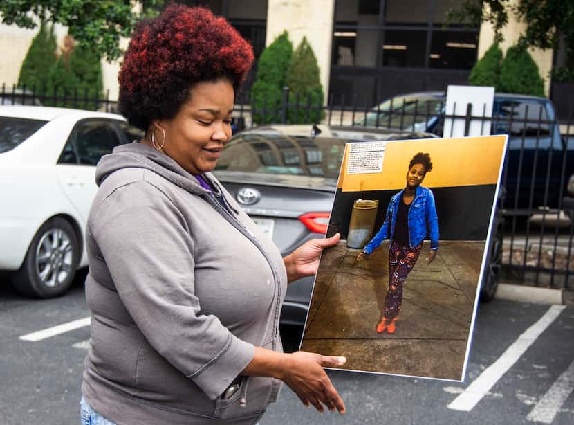 Shaquna Persley holds a picture of her daughter, Shavon Randle, as she exits the Earle...