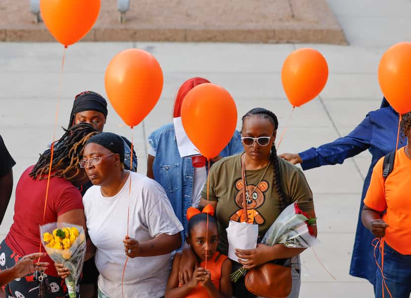 Nicole Johnson (center) stands with balloons alongside her family including her mother...