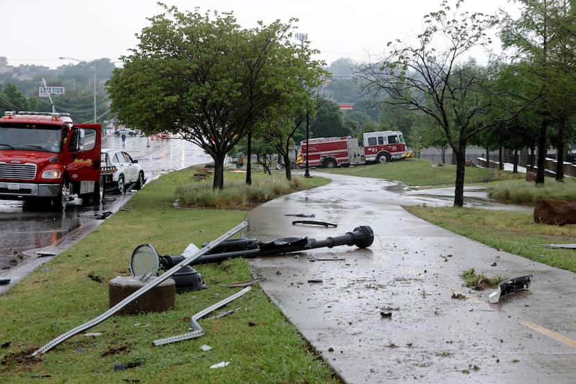 A light pole and other debris sit along the White Rock Lake Trail after a Dallas Fire-Rescue...