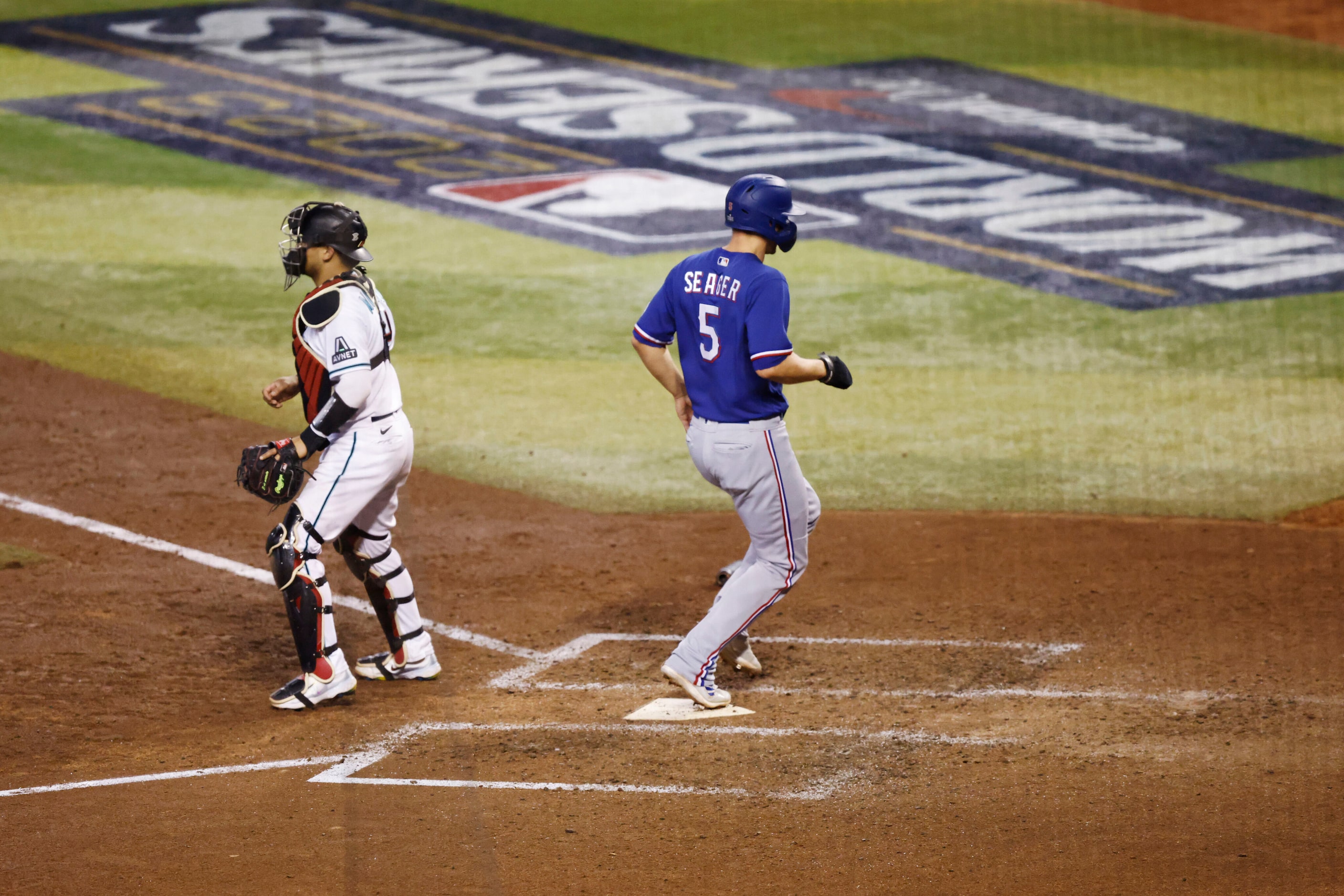 Texas Rangers’ Corey Seager (5) scores on an RBI single by designated hitter Mitch Garver...