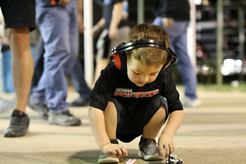Four-year-old Easton Obregon plays with his sprint cars at Devil's Bowl Speedway in...
