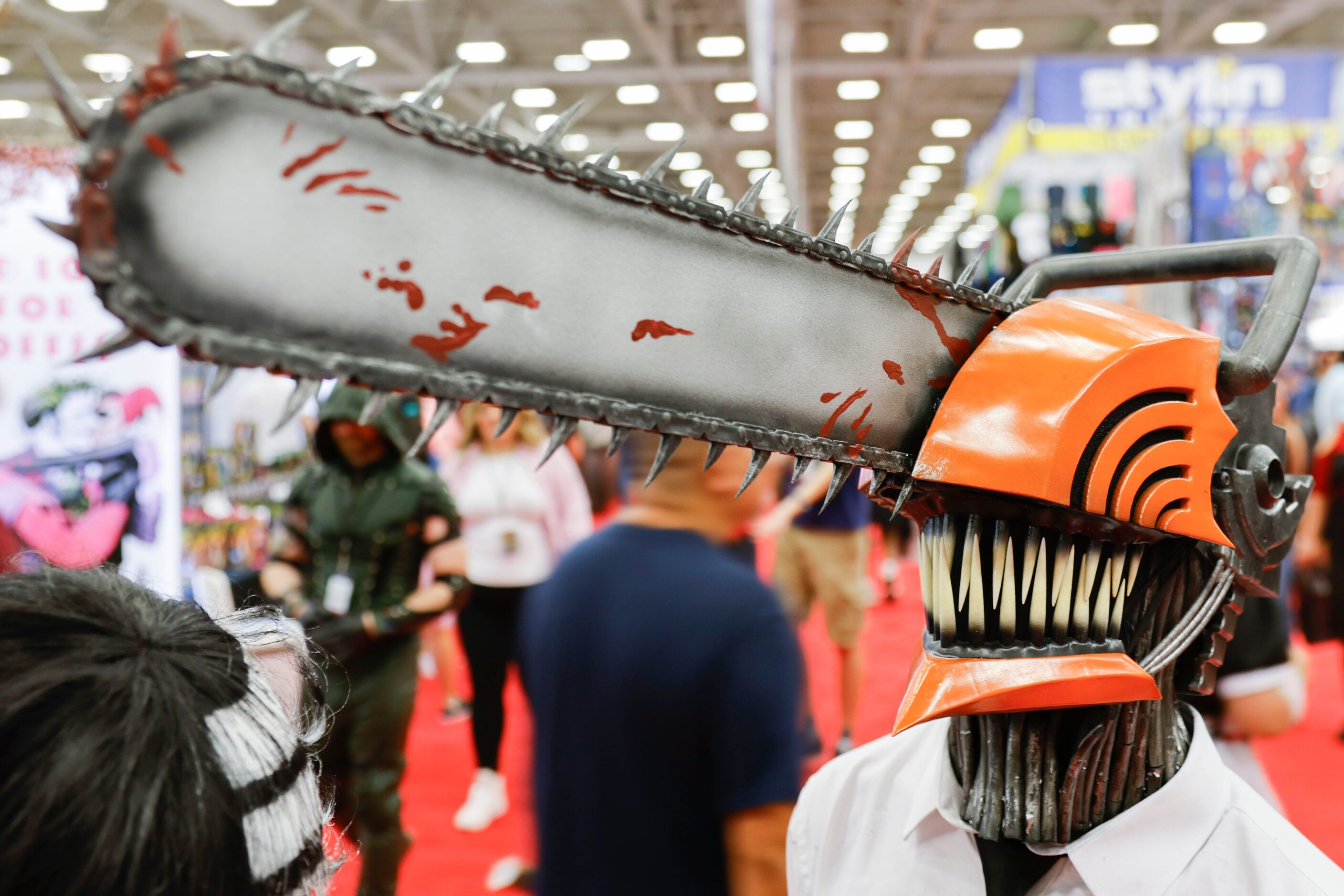 Ben Reed dressed as Chainsaw Man pauses while walking around during Fan Expo Dallas on...