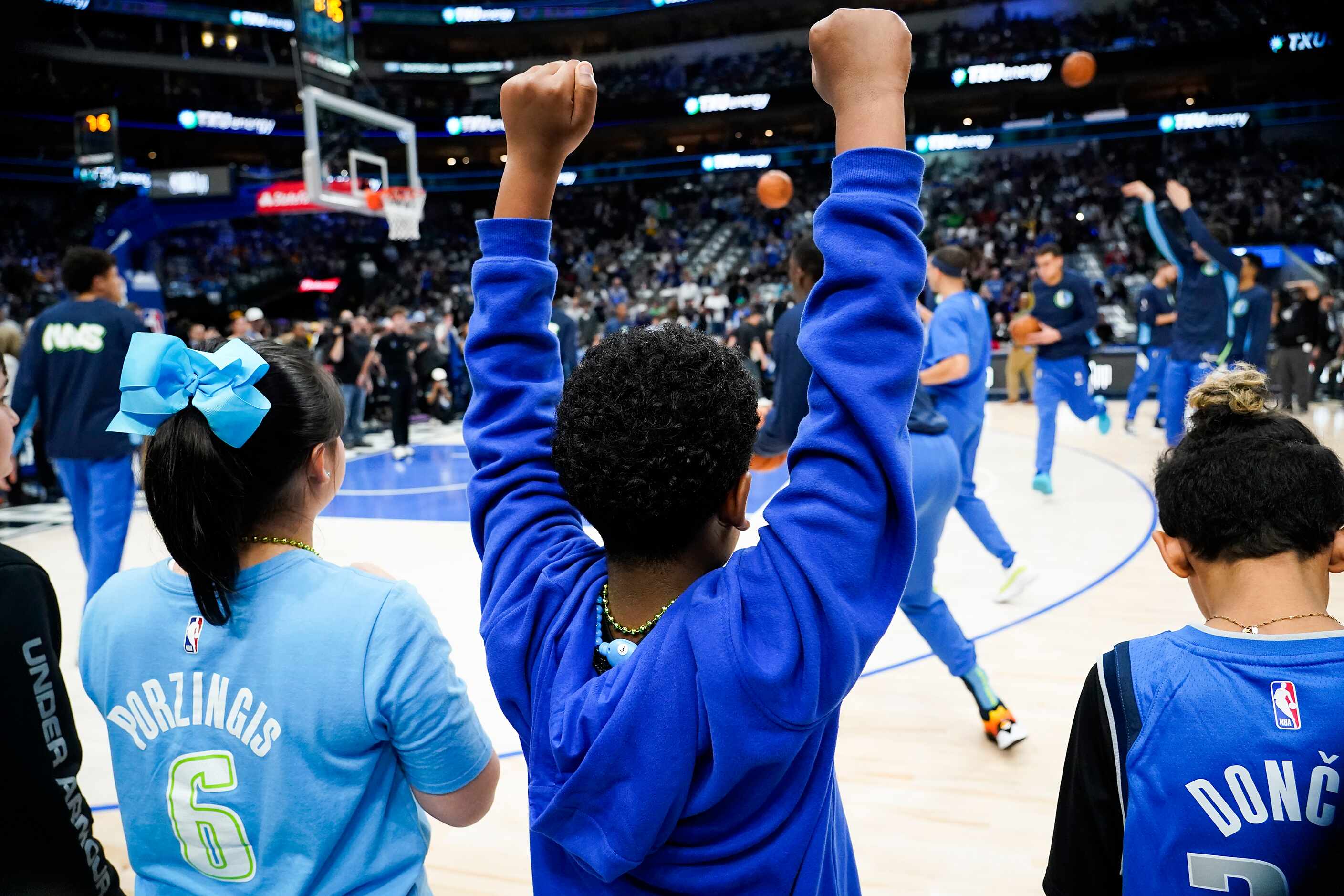 Young fans cheer as the Dallas Mavericks warm up before an NBA basketball game against the...