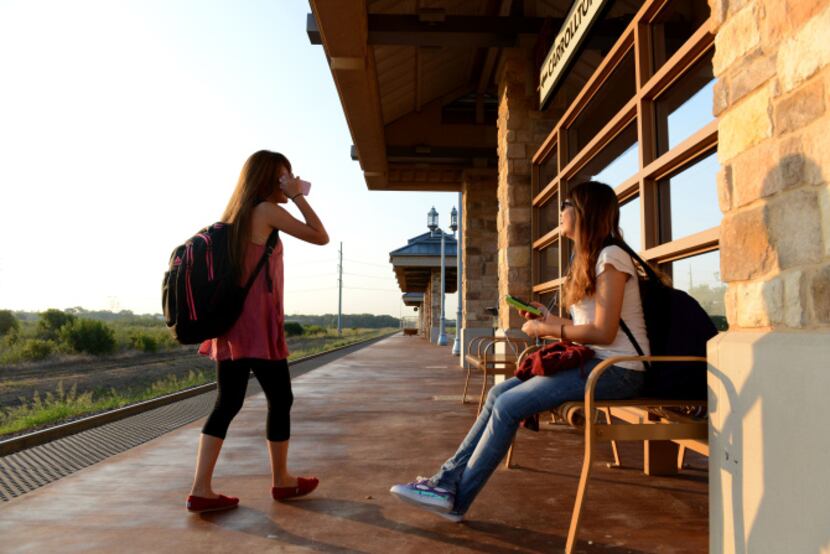 A-Train riders Jina Cha (left) and Melody Ann greet each other at Hebron Station in the...