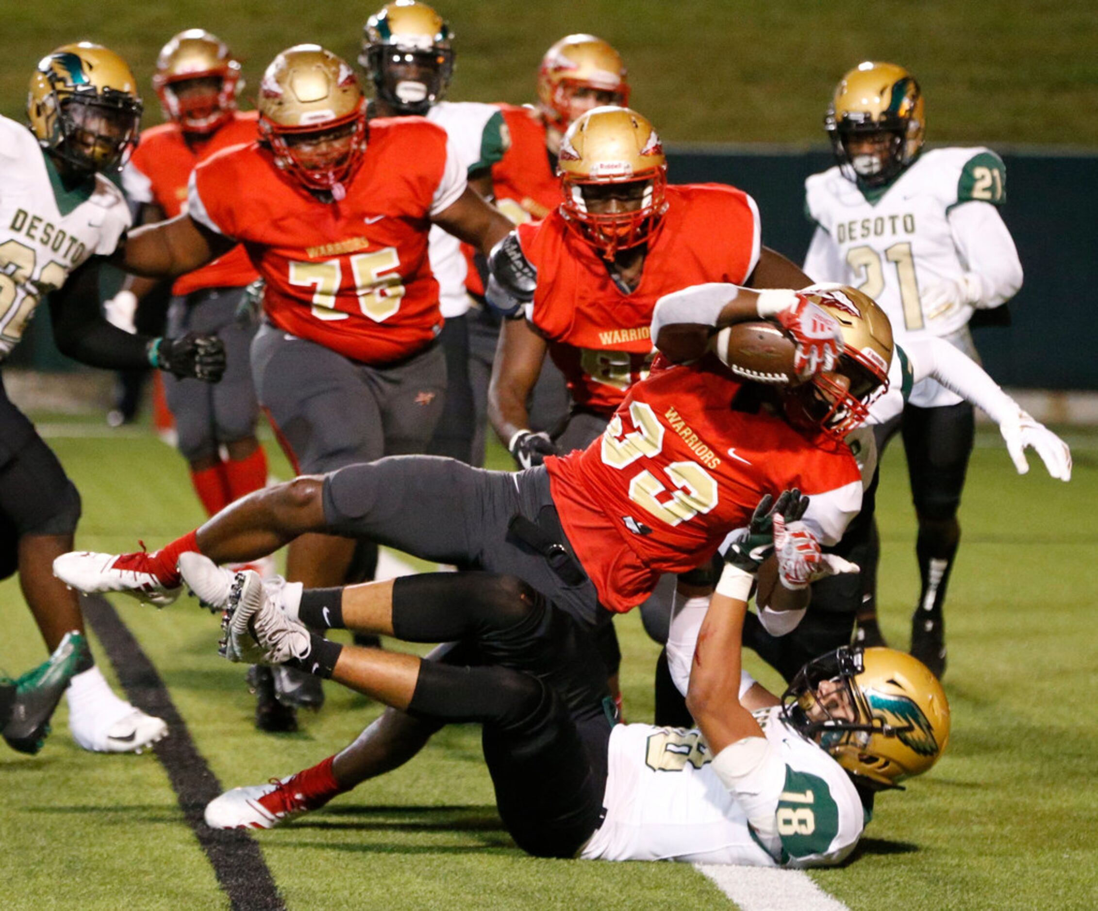 South Grand Prairie's Craig Woodson (33) jumps over Desoto's Austin Roland during the first...