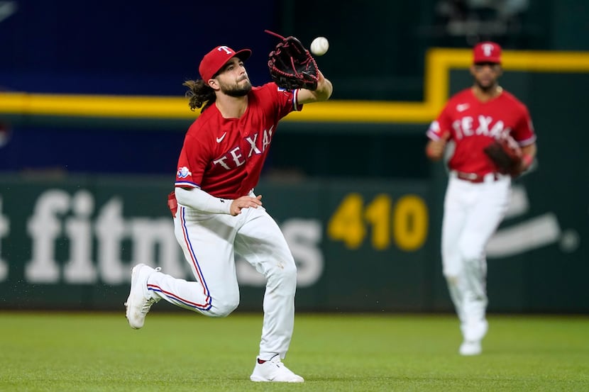 Texas Rangers left fielder Josh Smith, left, makes a running catch on a flyout by Seattle...