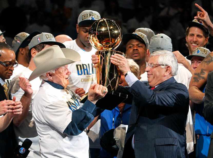 Dallas Mavericks former owner Don Carter (left) receives the Larry O'Brien Trophy from...