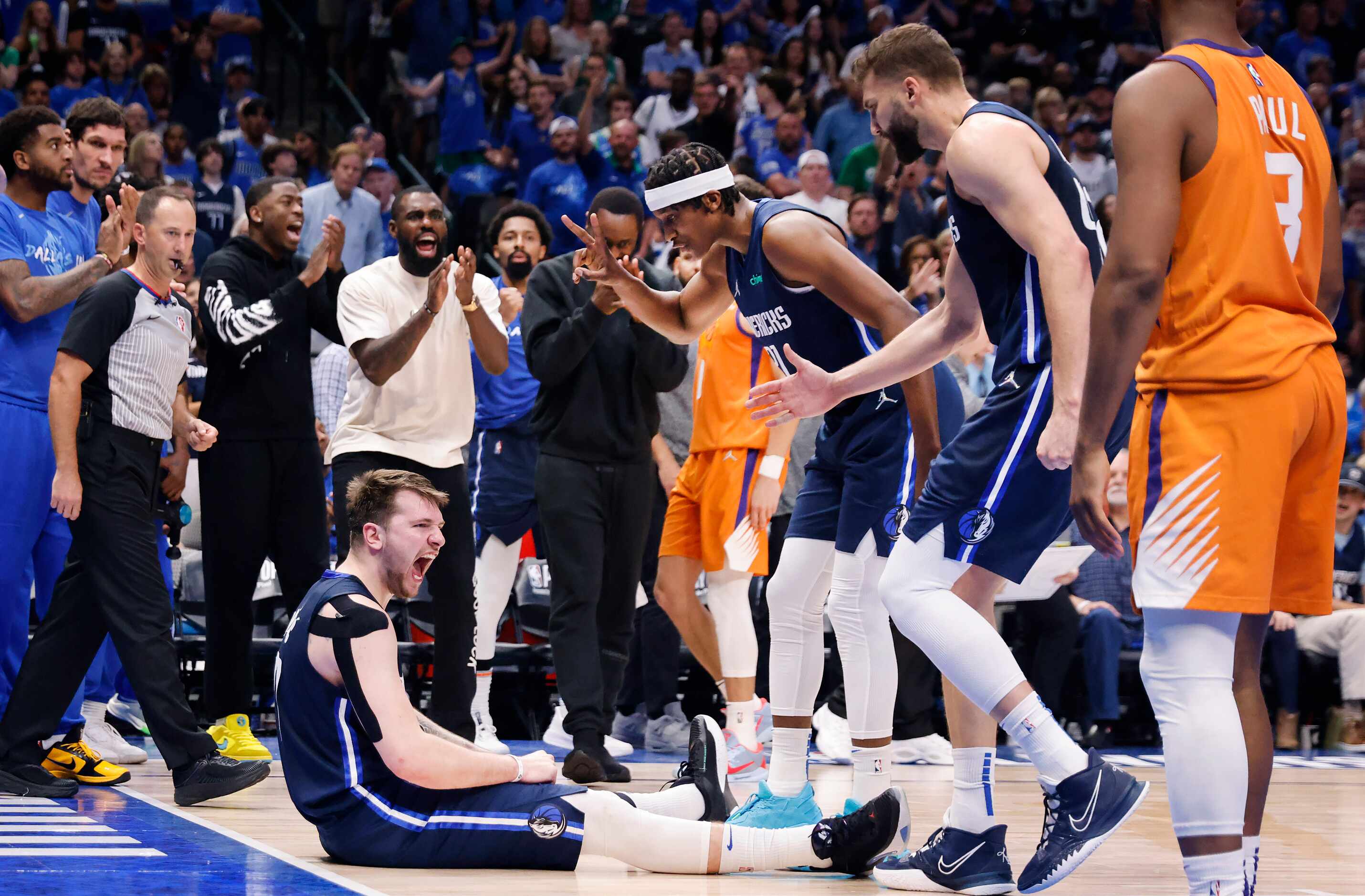 Dallas Mavericks guard Luka Doncic (77) and the rest of the bench react after he was fouled...