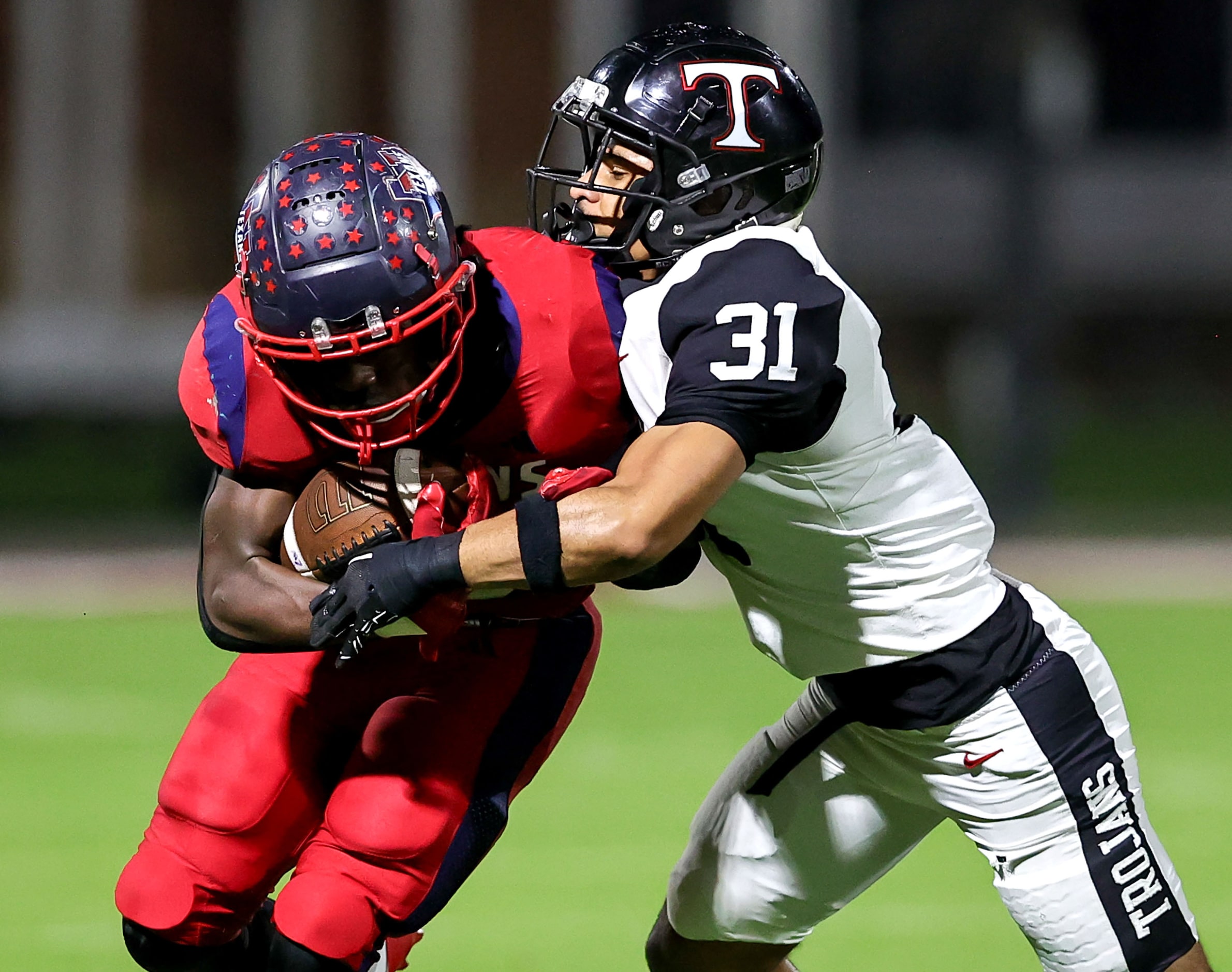 Justin Northwest running back Nate Jean (L) is stopped for no gain by Trinity linebacker...