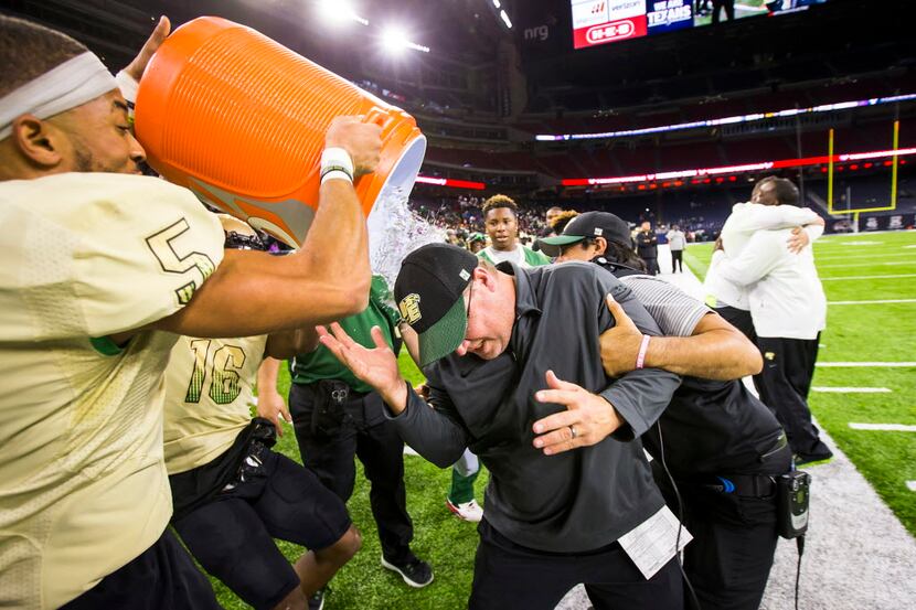 DeSoto head coach Todd Peterman  is doused with water by defensive back Byron Hanspard Jr....
