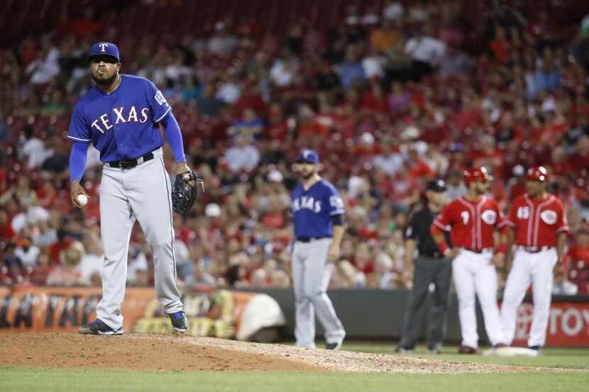 Texas Rangers relief pitcher Jeremy Jeffress, left, prepares to throw after walking...
