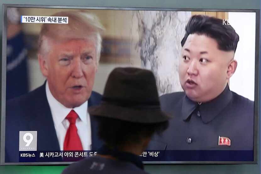 A man watched a television screen showing U.S. President Donald Trump and North Korean...