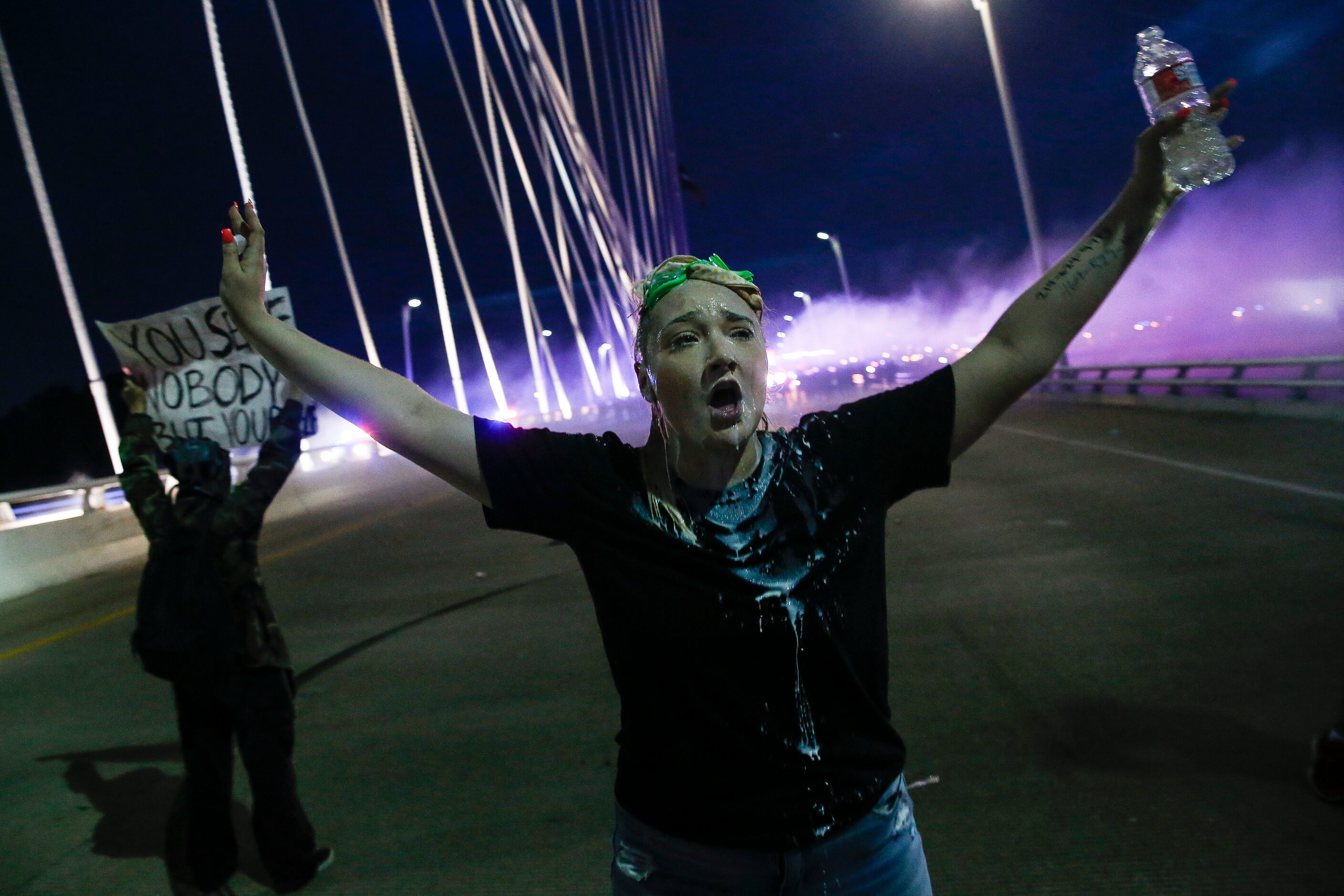 Police deploy smoke bombs and tear gas as they surround protesters who marched onto the...