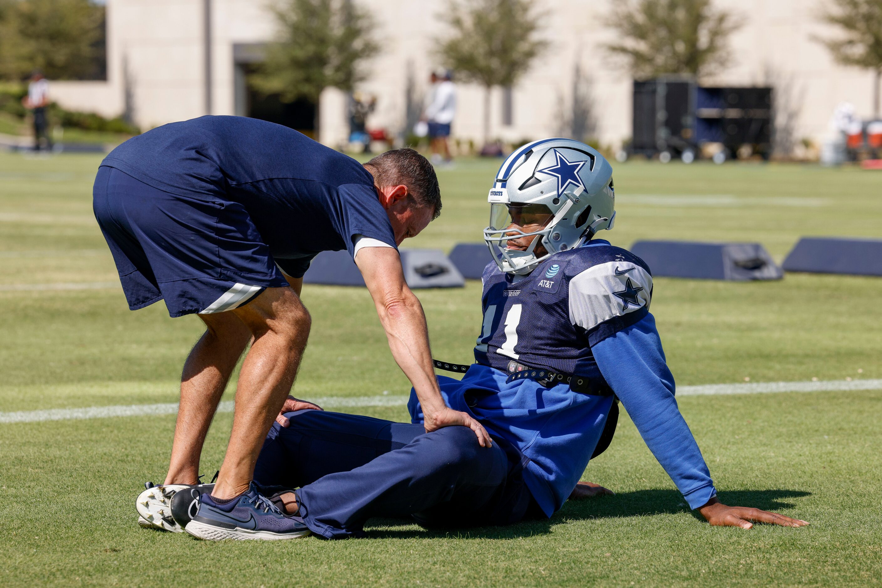 Dallas Cowboys linebacker Micah Parsons (11) stretches with staff during a practice at The...