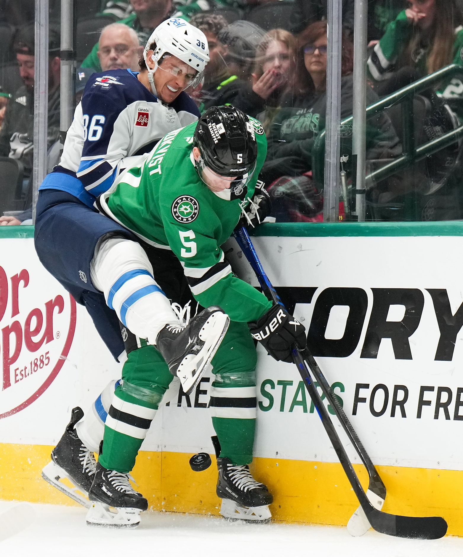 Dallas Stars defenseman Nils Lundkvist (5) fights for the puck against Winnipeg Jets center...