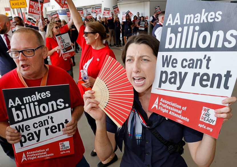 American Airlines flight attendant Rebecca Johnson, right, holds a sign as American Airlines...