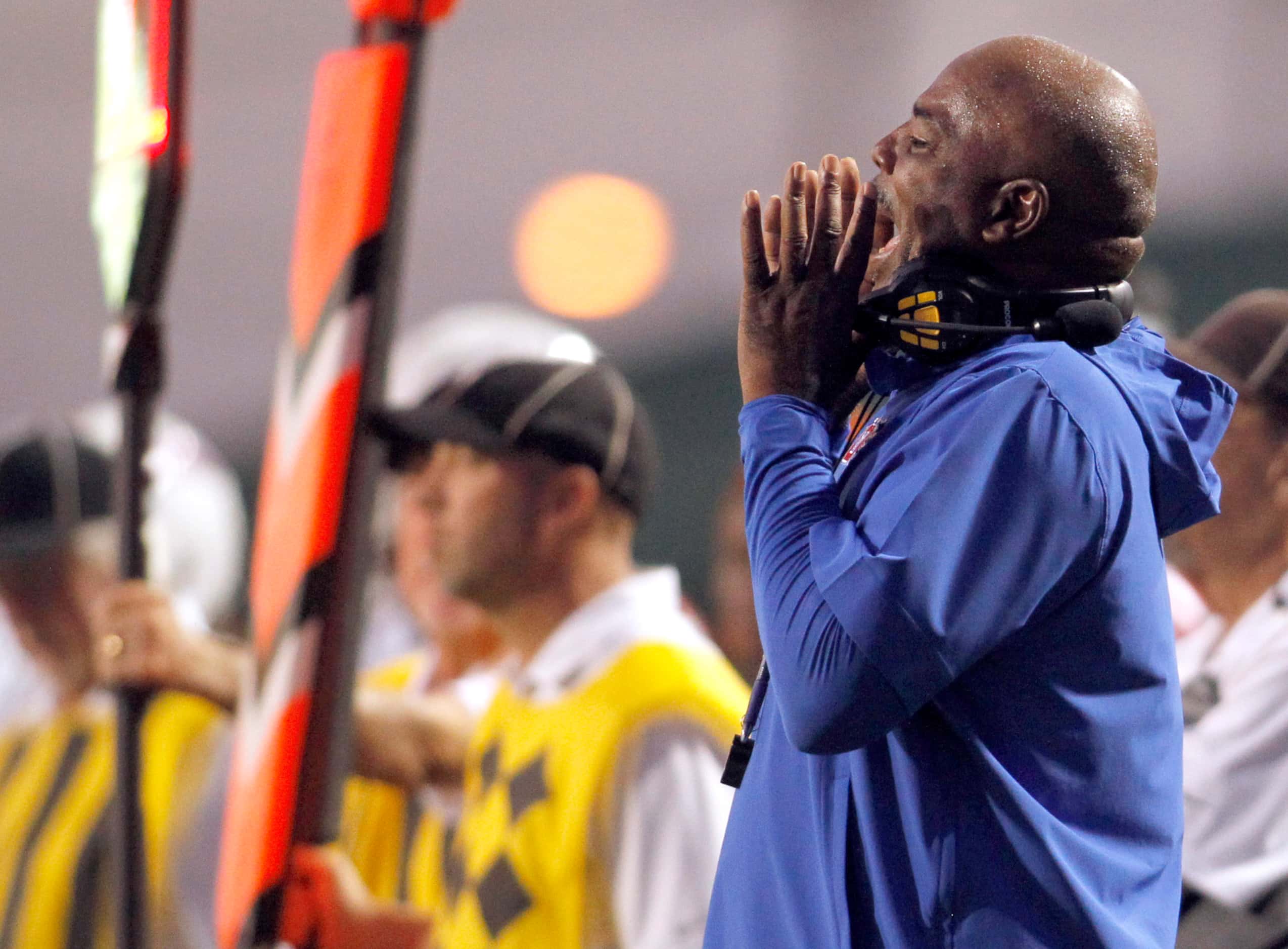 Duncanville head coach Reginald Samples sends a message to his players from the team bench...