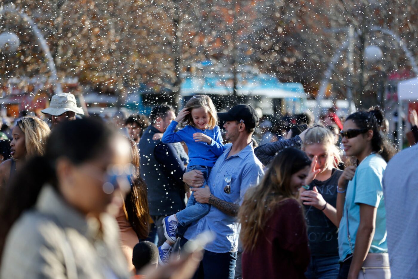 Josh Parman and his daughter James Parman, 6, enjoy the fake snow during the tree lighting...