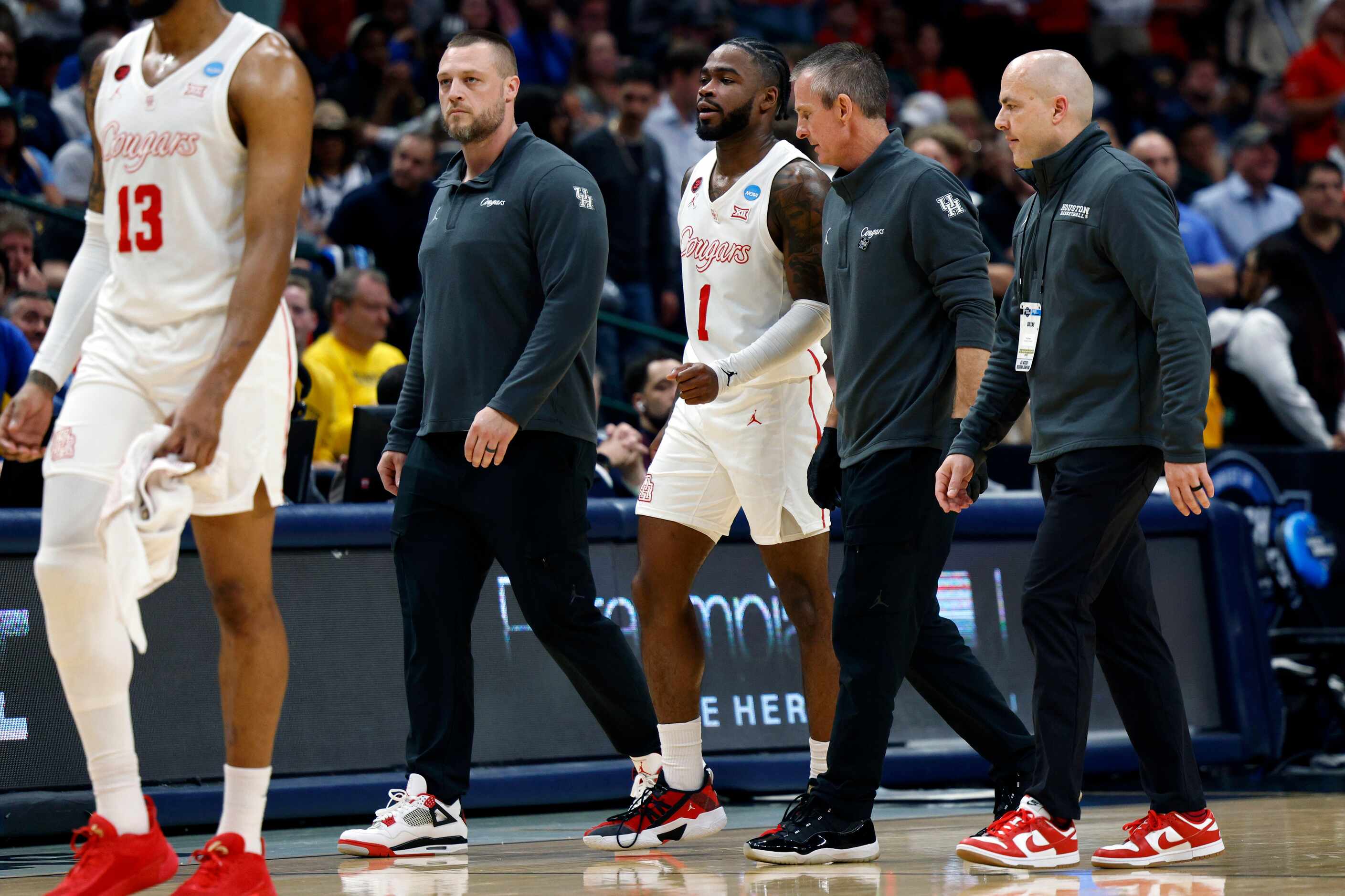 Houston guard Jamal Shead (1) is helped off the court after injuring his leg during the...