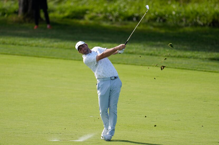 Scottie Scheffler hits on the 18th fairway during the third round of the Memorial golf...