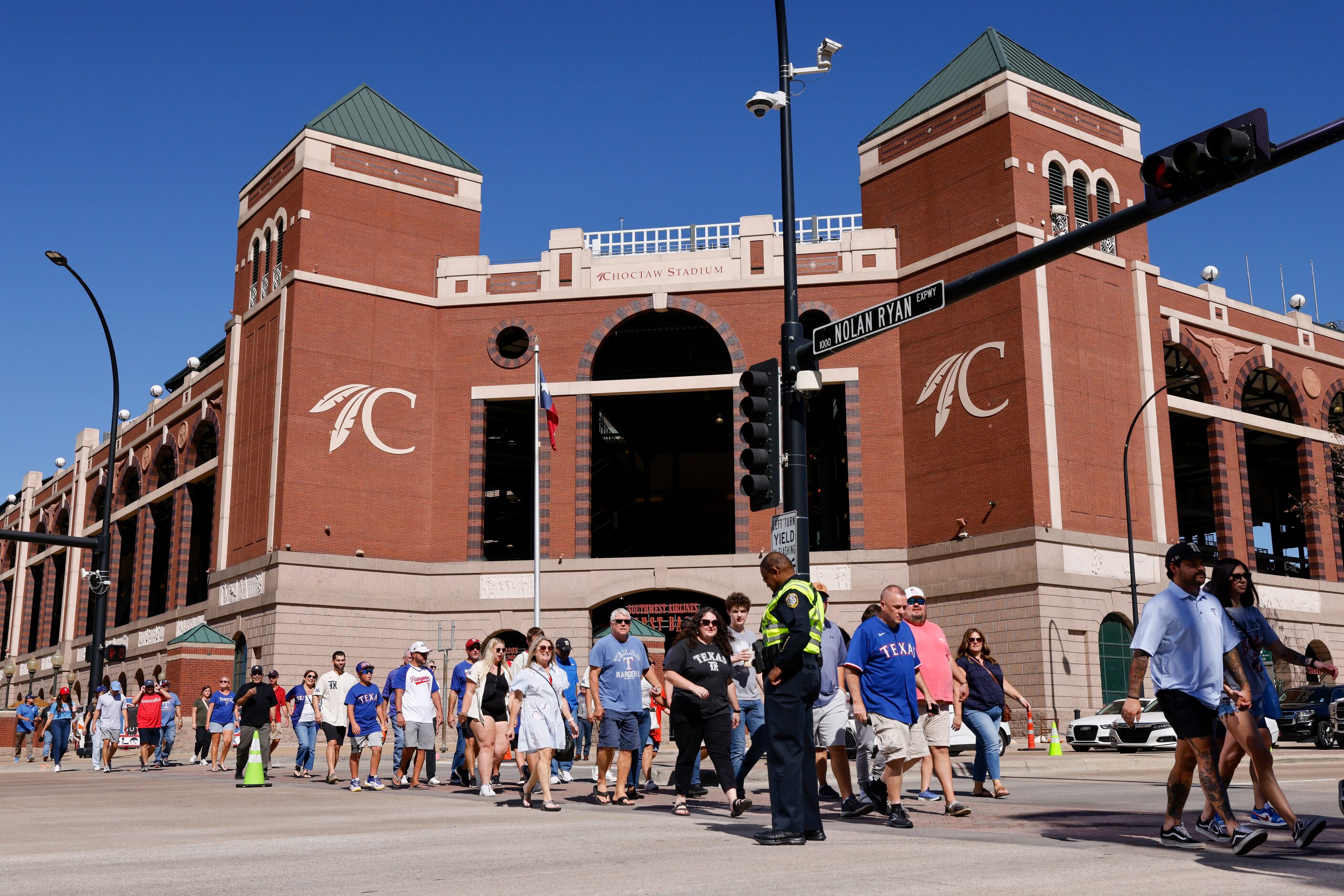 People cross Randol Mill Road near Choctaw Stadium before Game 4 of the American League...