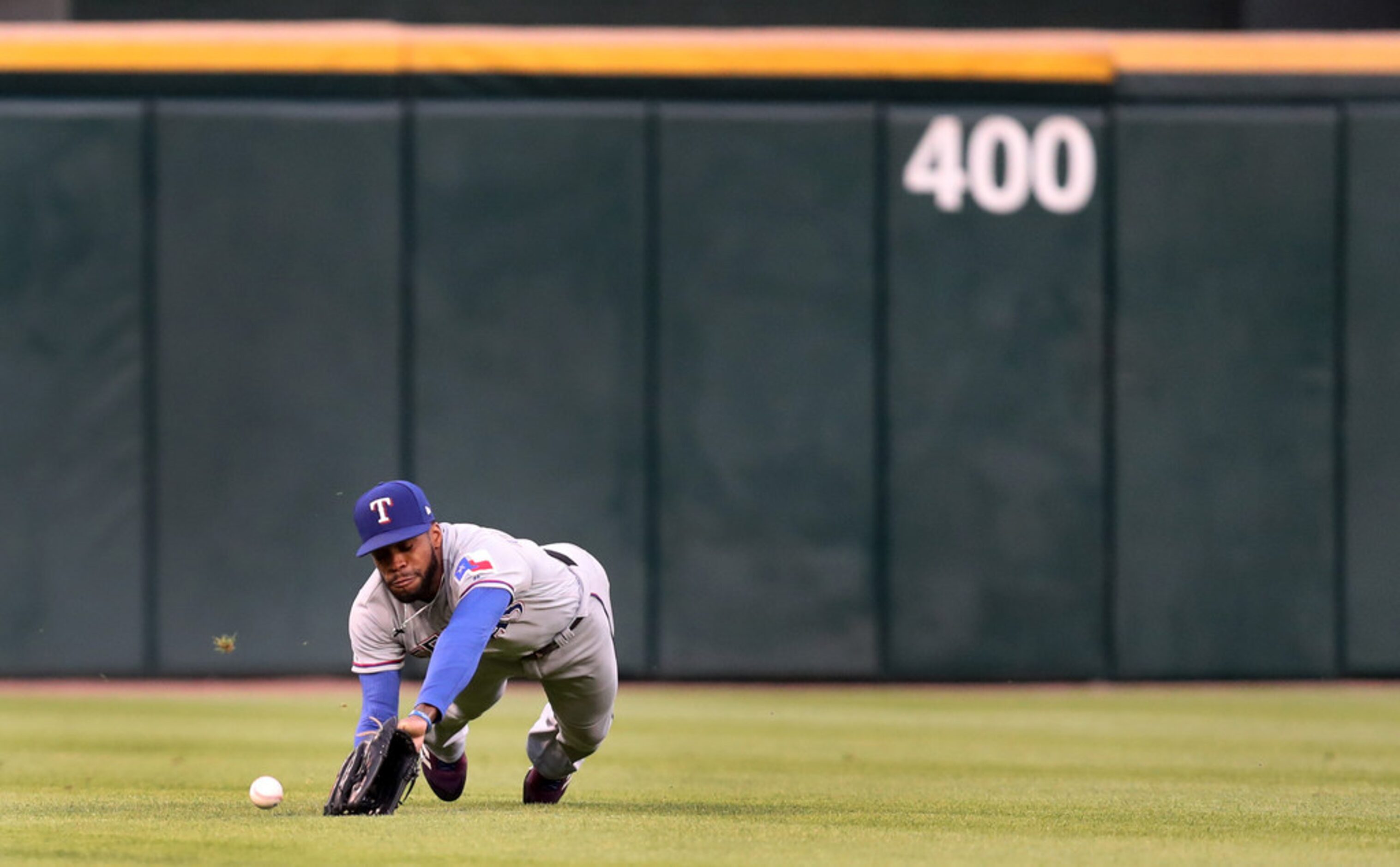 Texas Rangers center fielder Delino DeShields (3) is unable to catch a ball that went for a...