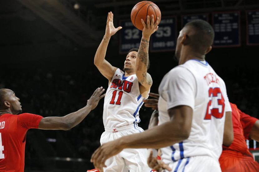 Houston's LeRon Barnes, left, defends against a shot attempt by SMU's Nic Moore (11) as...