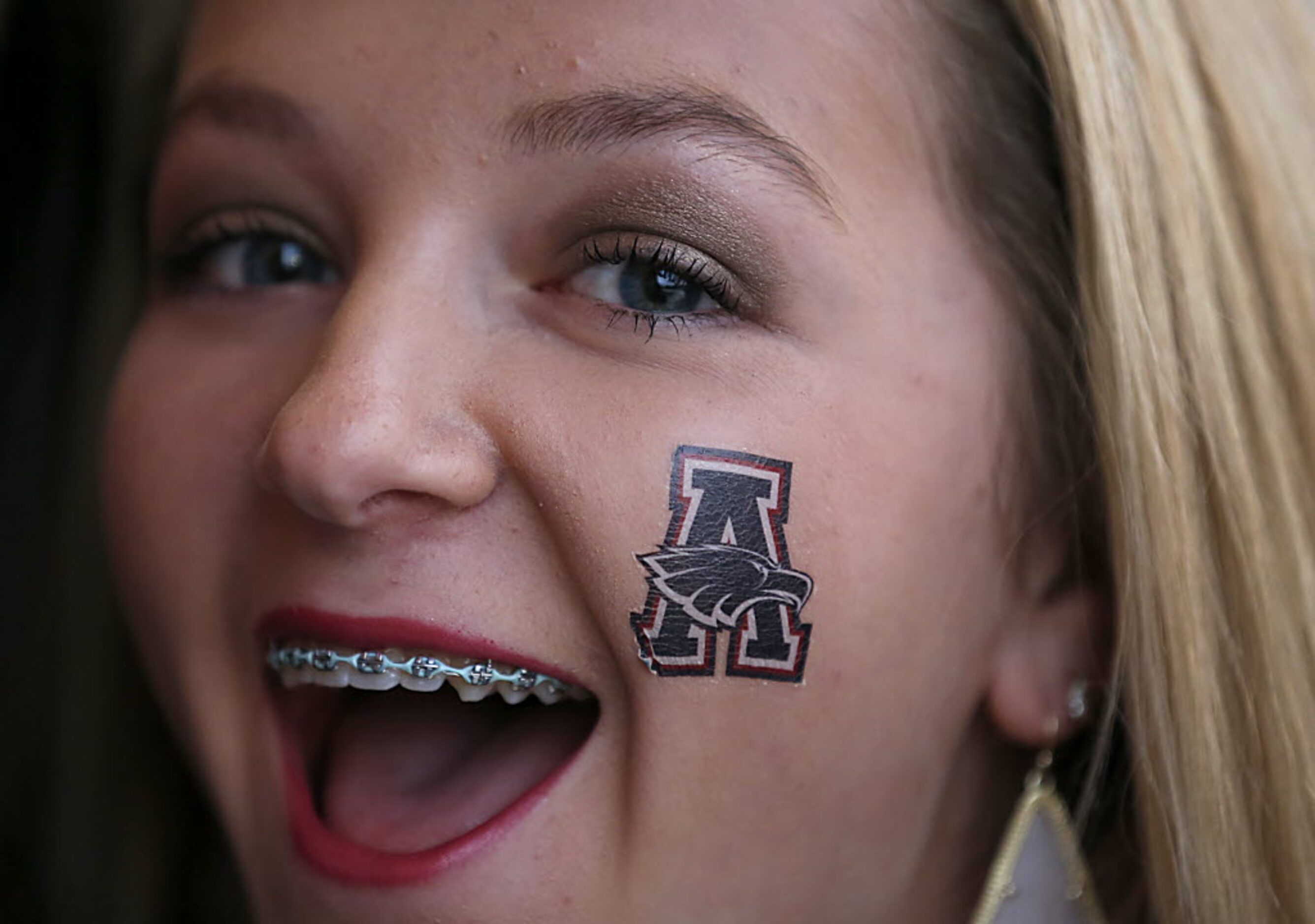 Allen fan Grace Krull, 17, smiles while waiting in line to enter the Eagle Stadium prior to...