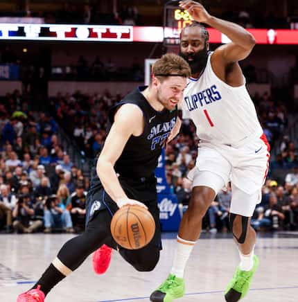 Dallas Mavericks guard Luka Doncic (left) dribbles past LA Clippers guard James Harden...