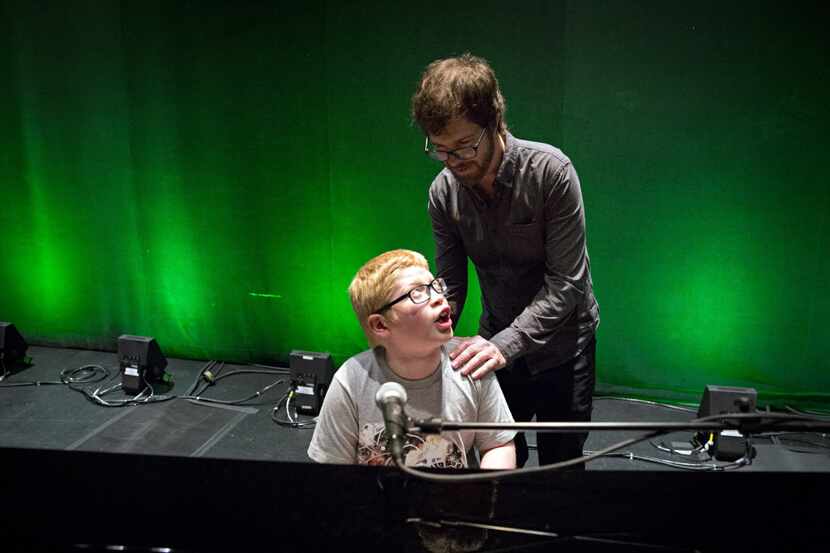 Musician Ben Folds (right) listens as Ben Schneider sings and plays at Folds' piano...