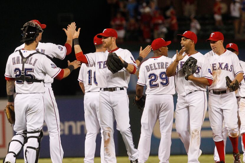 The Texas Rangers celebrate after beating  Chicago White Sox 2-0 at  Rangers Ballpark in...