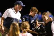 ESD quarterback Preston Morway (#3) gets his helmet worked on by trainer Emily Gill as...