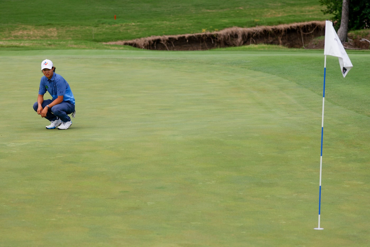 Amateur Kris Kim, 16, scouts his shot on the 12th green during the first round of The CJ Cup...