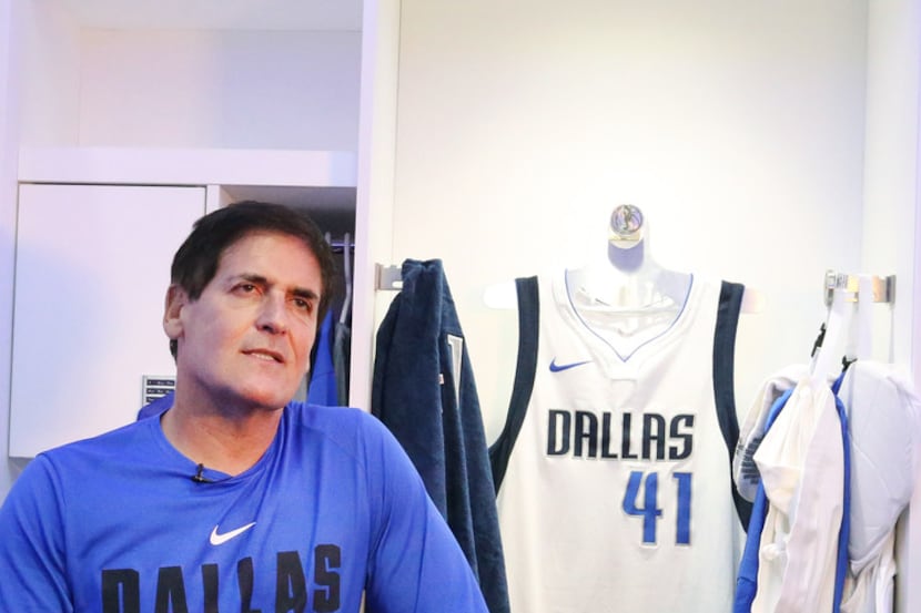 Dallas Mavericks owner Mark Cuban talks with the media in front of Dirk Nowitzki's locker...