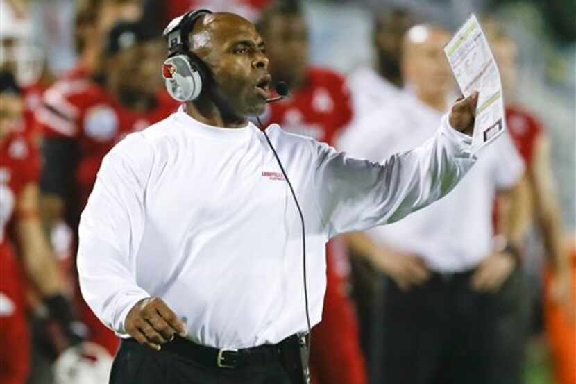 Louisville coach Charlie Strong calls out to players on the field during the second half of...