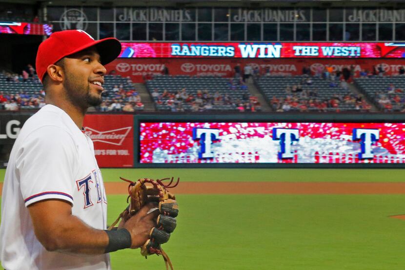 Texas Rangers shortstop Elvis Andrus (1) warms up before the game as the scoreboard...