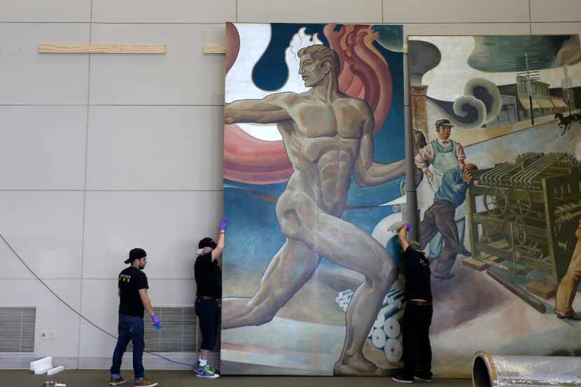 Workers from Unified Fine Arts work to remove the murals from the wall of TXCN on Tuesday,...