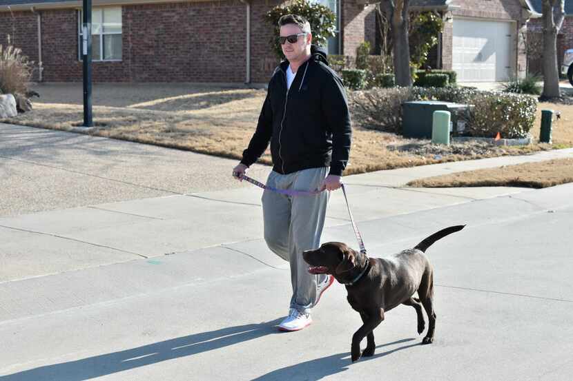 Bret Pels walks his dog in the Country Lakes neighborhood near the intersection of Sandy...