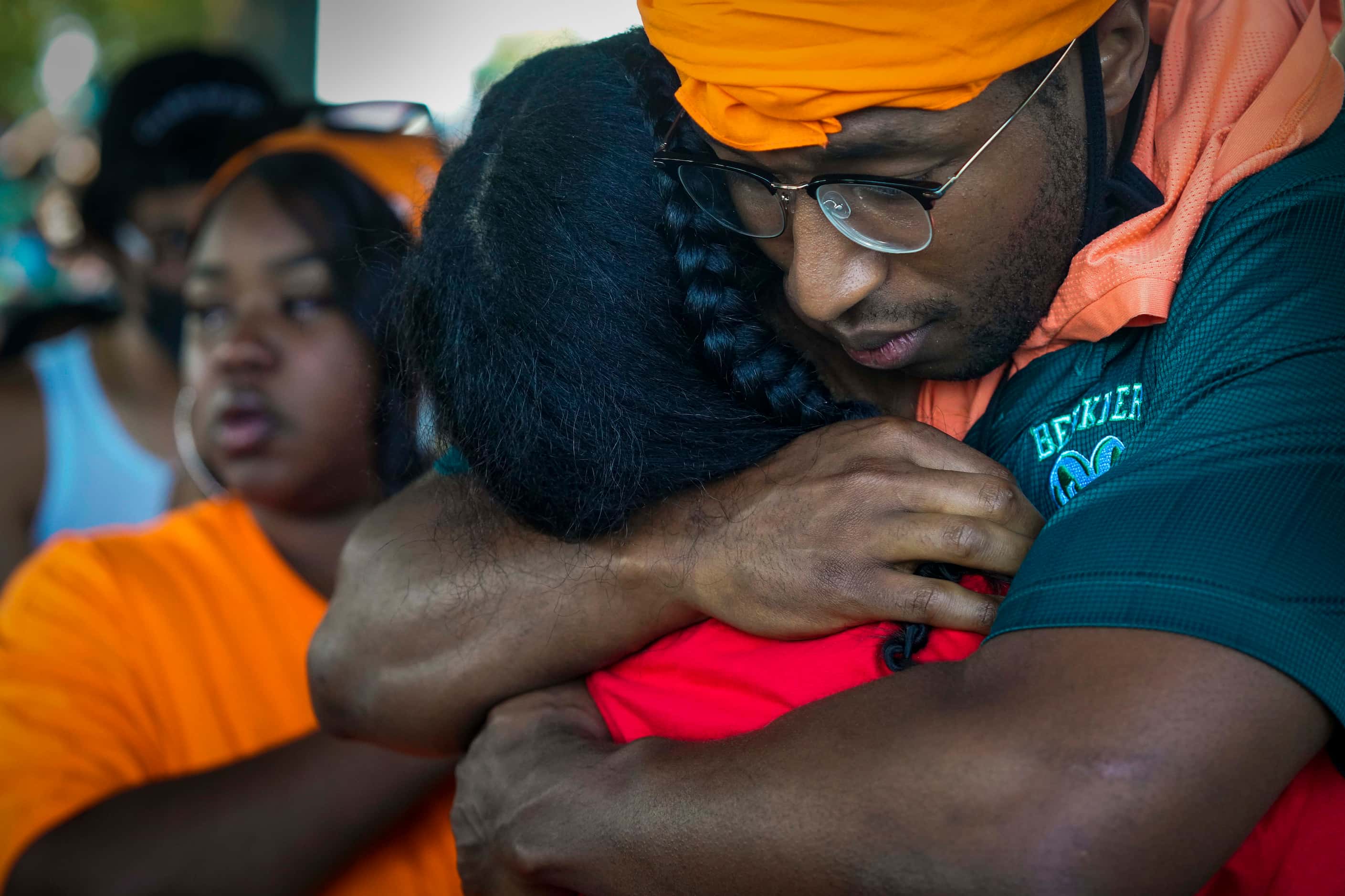 Teacher Andre Watson (right) hugs a speaker during a protest organized by Berkner High...