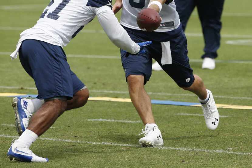 Dallas Cowboys quarterback Tony Romo (9) hands the ball off to running back Ezekiel Elliott...