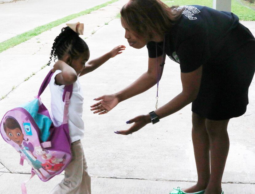 Principal Onjaleke Brown greets student Skylar Thompson as she arrives at Harllee Early...