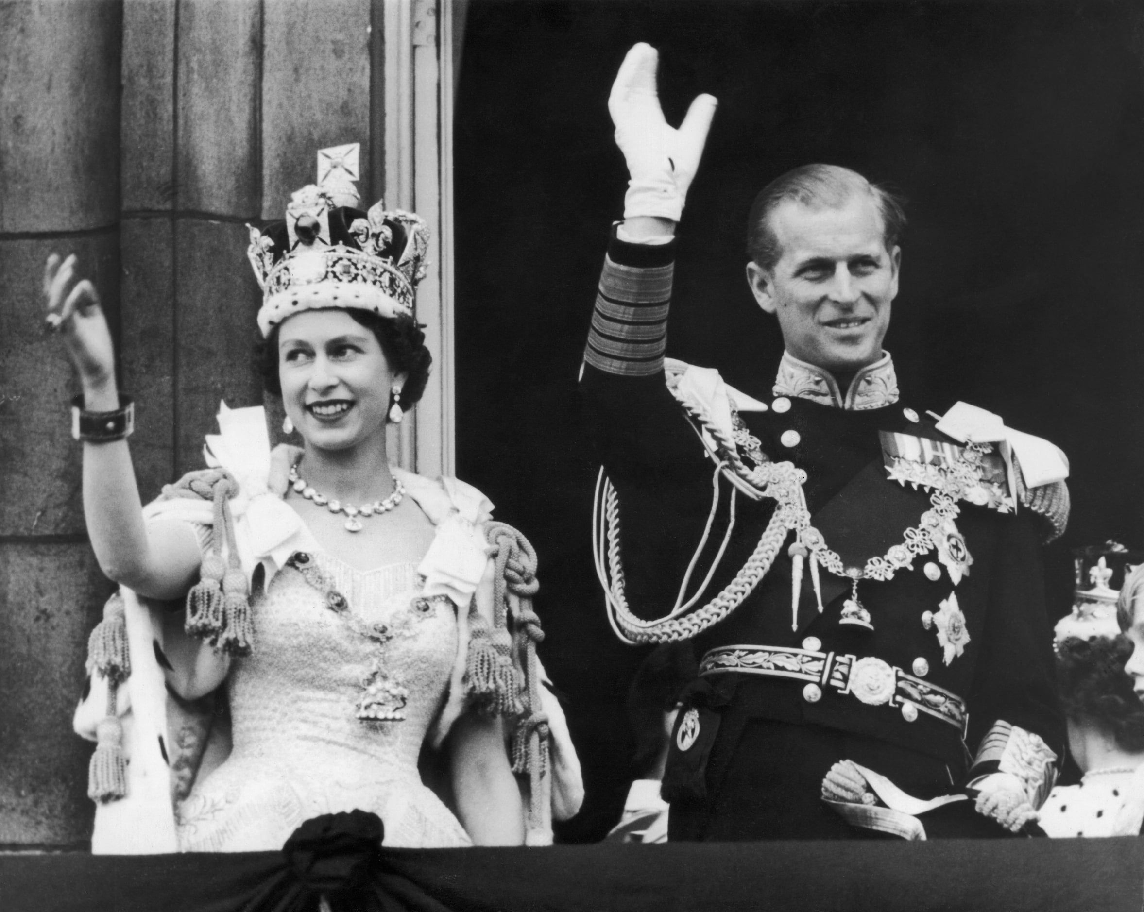 Queen Elizabeth II and the Duke of Edinburgh wave at the crowds from the balcony at...