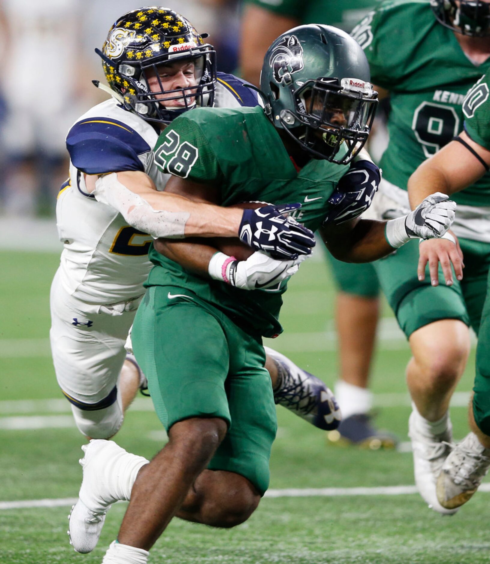 Kennedale's DJ Kirven (28) is tackled by Stephenville's Gage Graham (25) during the first...