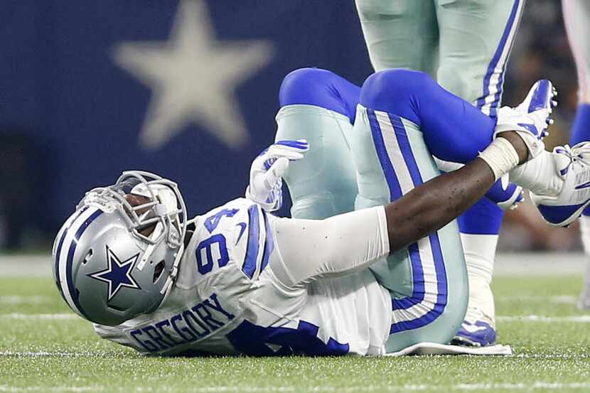 Dallas Cowboys defensive end Randy Gregory (94) holds his leg after suffering an injury...