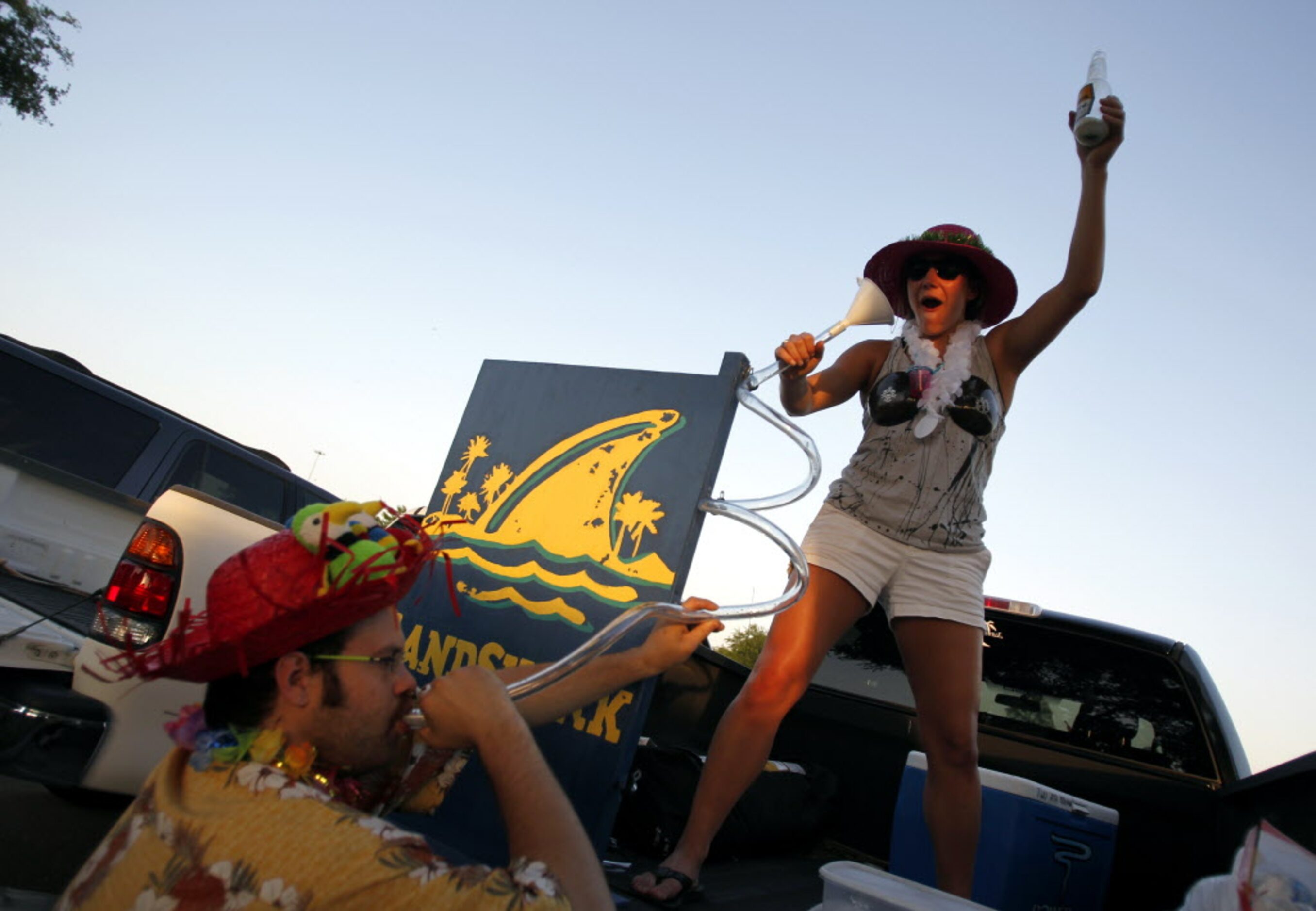 Train Edmondson drinks out of a beer bong while Mollie Blessing pours in the parking lot...