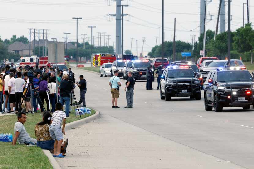 Law enforcement, people and media gather along Chelsea Boulevard after a mass shooting at...