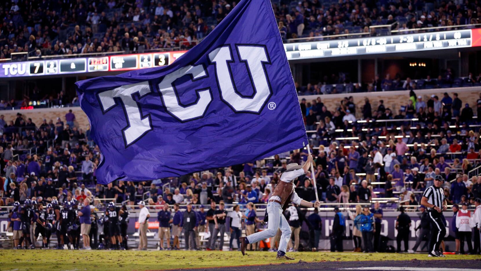 A member of the TCU Horned Frog Wranglers waves the school flag after a first half score...