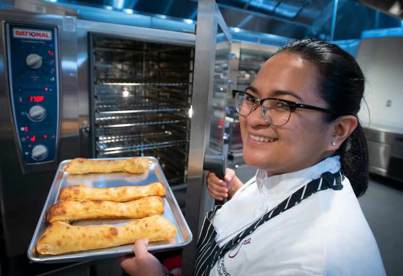 Pastry chef Cessy Mendoza with a batch of stecca, an Australian bread that's like a cross...
