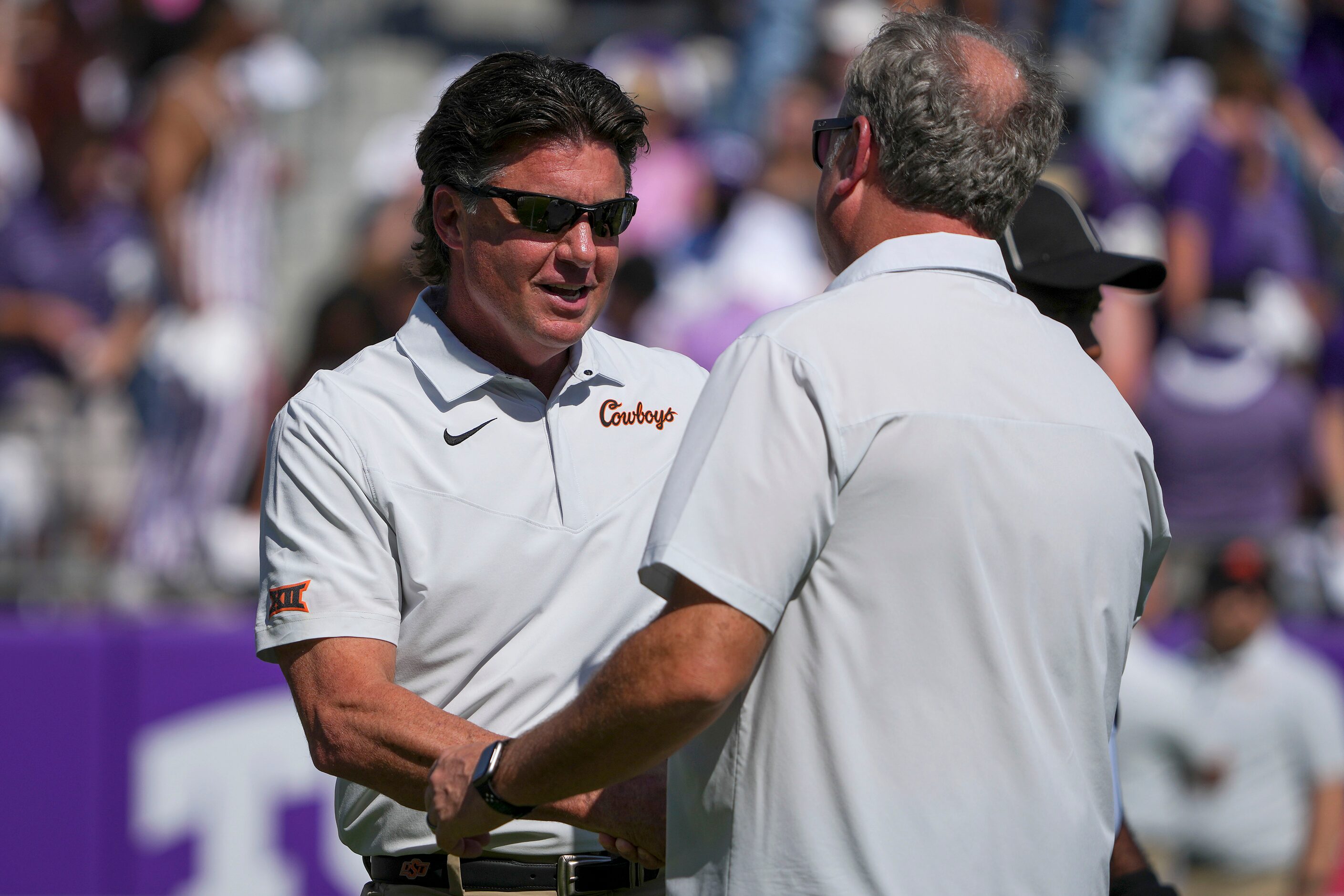 Oklahoma State head coach Mike Gundy shakes hands with TCU head coach Sonny Dykes before an...