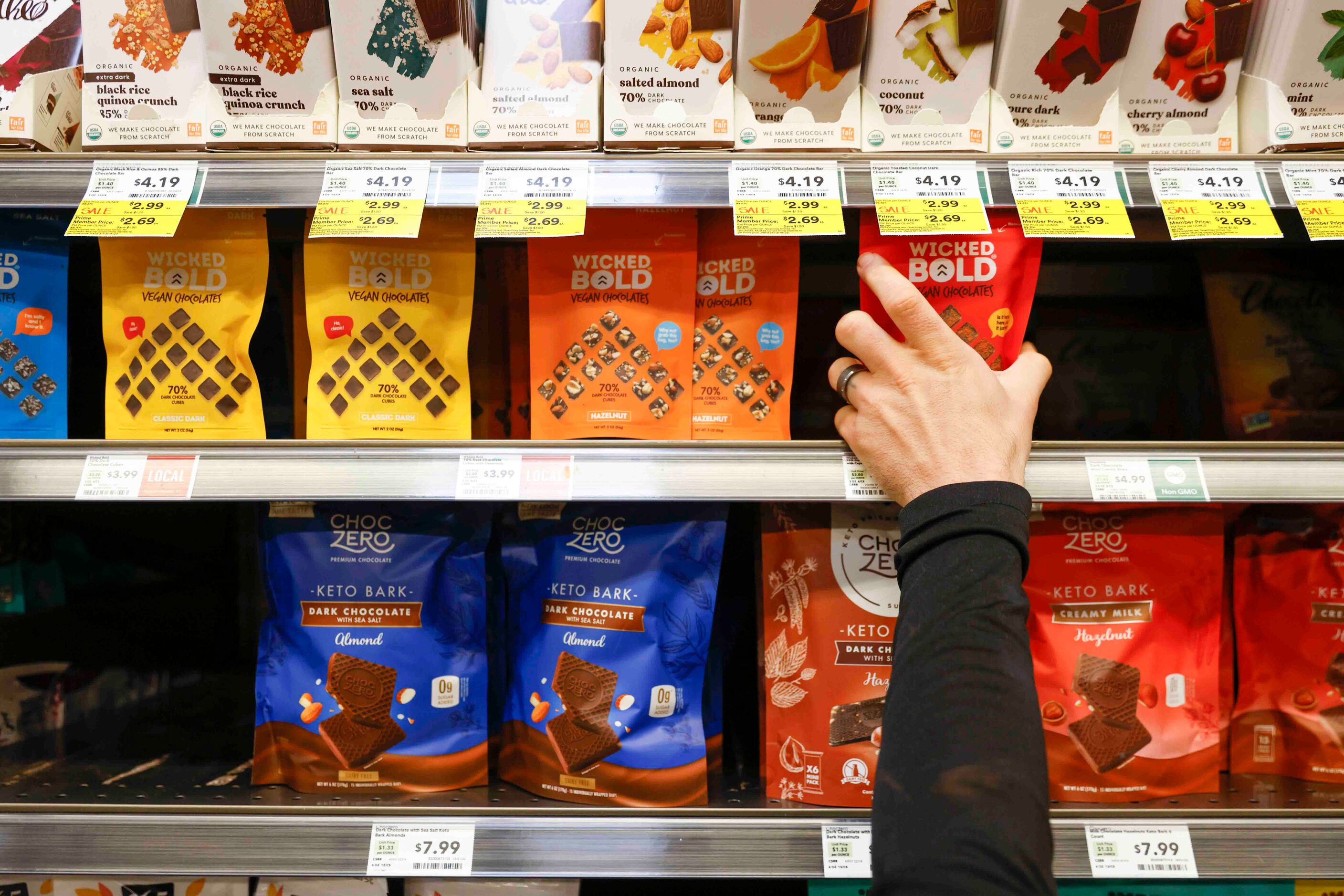 Deric Cahill straightens up the shelves and the Whole Foods Market in Addison. 